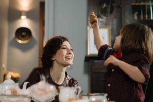 babysitter and boy at the kitchen table smiling